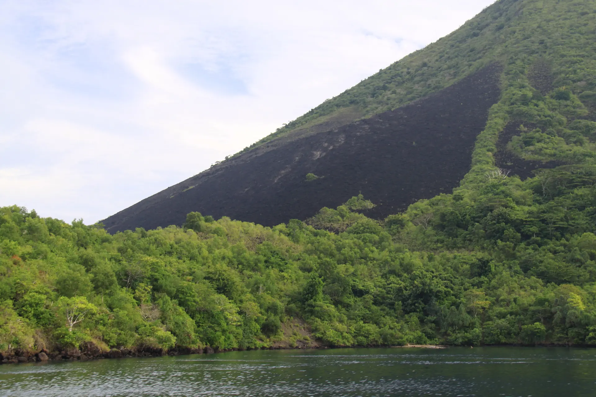 Der Vulkan Gunung Api ragt über den Banda Neira harbour empor